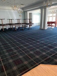 Community Center Renovation update – dining room carpet complete furniture and piano in background