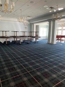 Community Center Renovation update – dining room carpet with furniture and piano in background